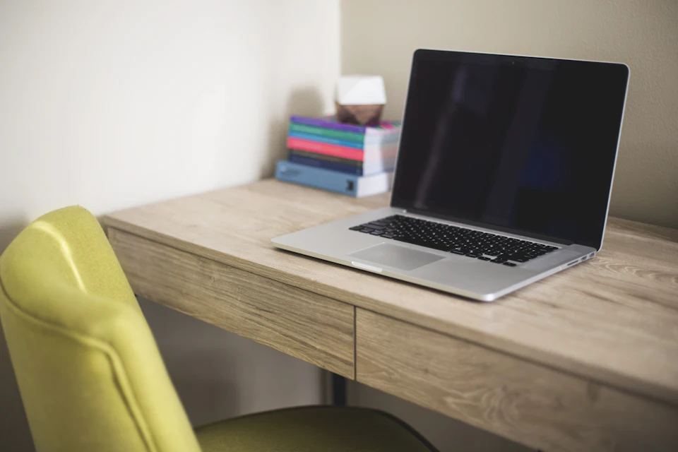 Silver laptop on a brown wooden desk